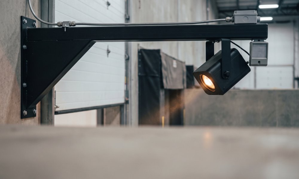 Potence U-Dock installée au-dessus d'une porte de quai, avec le projecteur et le capteur