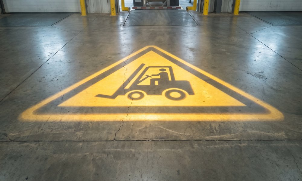 Pictogramme « Attention chariot » projeté au sol devant la porte de quai
